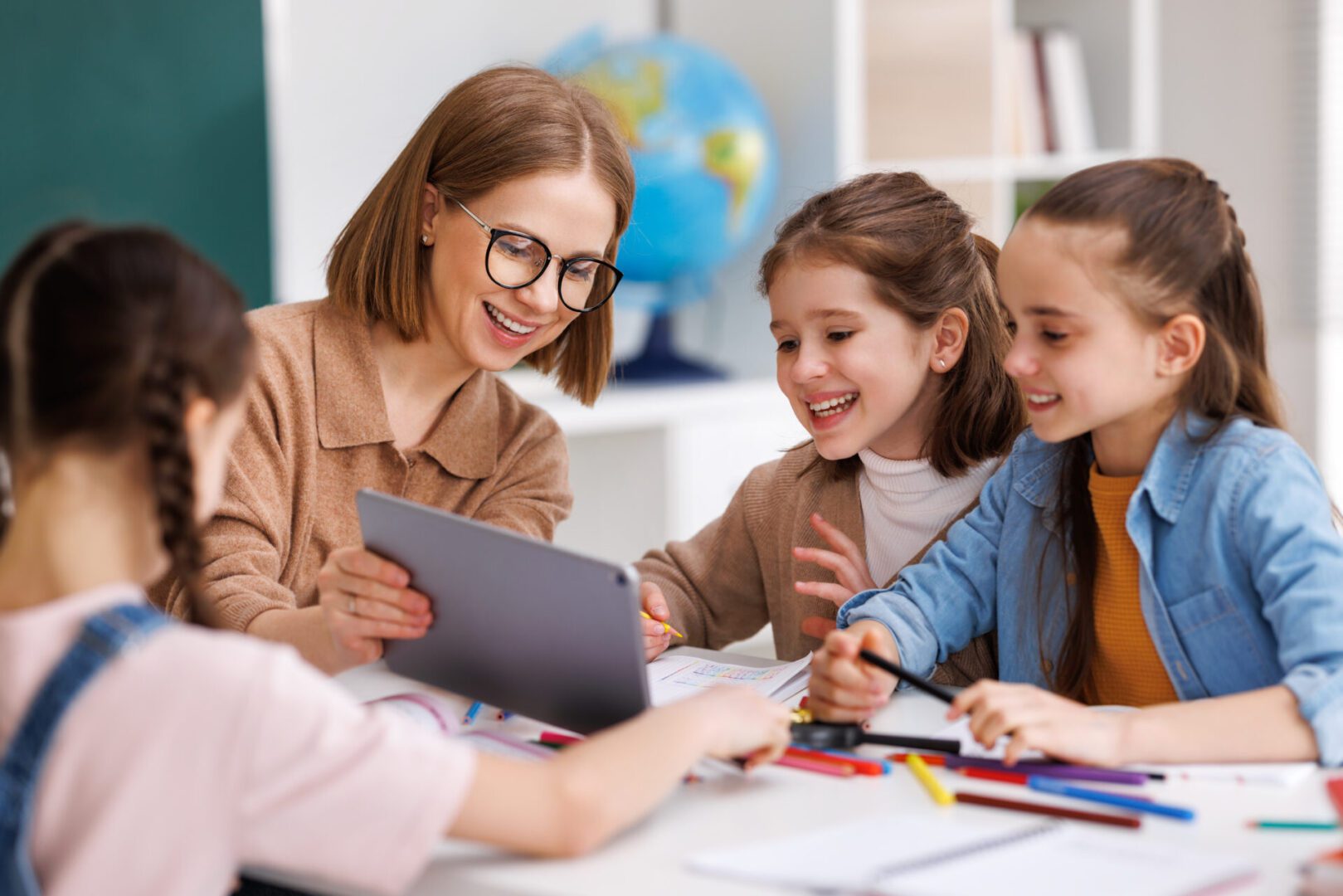 Teacher and students using tablet in classroom.